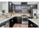 Modern kitchen with dark cabinetry, granite countertops, and stainless steel appliances at 11712 Blessington Rd, Huntersville, NC 28078