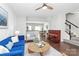 Open living space with blue sofa, piano, and hardwood floors at 11712 Blessington Rd, Huntersville, NC 28078