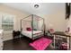 Bedroom featuring dark floors, natural light, pink accents, and a canopy bed frame at 16827 Monocacy Blvd, Huntersville, NC 28078