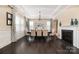 Formal dining room featuring a fireplace, wainscoting, modern chandelier, and hardwood flooring at 16827 Monocacy Blvd, Huntersville, NC 28078