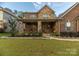 Charming two-story home with stone and brick facade, covered porch, and well-manicured lawn at 16827 Monocacy Blvd, Huntersville, NC 28078