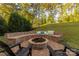 Cozy backyard fire pit with built-in seating and lush landscaping offers a relaxing outdoor experience at 16827 Monocacy Blvd, Huntersville, NC 28078