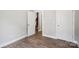 Empty bedroom features wood floors, a neutral color scheme, and white doors and trim at 552 Fern Hill Rd # 21, Mooresville, NC 28117