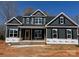 New two-story home featuring dark siding, white trim, symmetrical windows, and a covered front porch at 552 Fern Hill Rd # 21, Mooresville, NC 28117