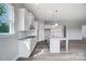 Bright kitchen features white cabinets, stainless steel appliances, granite countertops, and wood-look floors at 552 Fern Hill Rd # 21, Mooresville, NC 28117
