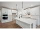 Bright, modern kitchen features white cabinetry, a center island with quartz countertop, and stainless steel appliances at 552 Fern Hill Rd # 21, Mooresville, NC 28117