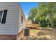 View of home exterior, deck, and HVAC system, nestled amongst mature trees at 1003 Woodland Dr, Gastonia, NC 28054