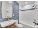 Bathroom featuring stylish wallpaper, modern vanity, and a shower-tub with white subway tile surround at 1003 Woodland Dr, Gastonia, NC 28054