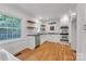 Modern kitchen with white cabinets, stainless steel appliances, floating shelves, and hardwood floors at 1003 Woodland Dr, Gastonia, NC 28054