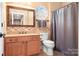 Bathroom with wood vanity, framed mirror, tiled floors, and shower-tub combination at 15909 Woodcote Dr, Huntersville, NC 28078