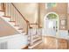 Bright foyer with wood flooring, staircase, and arched window over the front door at 15909 Woodcote Dr, Huntersville, NC 28078