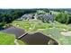 Scenic aerial view of the golf course, clubhouse, and water feature at Northstone at 15909 Woodcote Dr, Huntersville, NC 28078