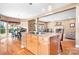 Open kitchen with granite counters, wood cabinets, eat-in island, and adjacent dining area at 15909 Woodcote Dr, Huntersville, NC 28078