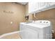 Functional laundry room with washer, dryer, storage cabinets, and utility sink at 15909 Woodcote Dr, Huntersville, NC 28078