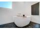 Sleek bathroom featuring a modern soaking tub, minimalist decor, and ample natural light at 2107 W Trade St, Charlotte, NC 28216