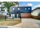 Contemporary two-story home boasting a sleek black exterior, complemented by a stained wood garage door at 2107 W Trade St, Charlotte, NC 28216