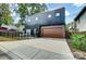 This is a modern home with a black exterior, a stained wood garage door, and a concrete driveway at 2107 W Trade St, Charlotte, NC 28216