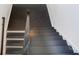 Modern staircase design showcasing dark wood steps and a contemporary railing against a white wall at 2107 W Trade St, Charlotte, NC 28216