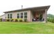 Well-maintained backyard with lush green grass, tidy landscaping and a covered patio at 2413 Riparian Way, Denver, NC 28037