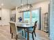 Bright dining room features modern lighting, wood floors, and large window with a view at 2413 Riparian Way, Denver, NC 28037