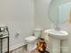 Stylish half bathroom with modern fixtures, round mirror and pedestal sink, ideal for guests at 2413 Riparian Way, Denver, NC 28037