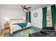 Bright bedroom with a king-size bed, teal blanket, and green velvet curtains at 4114 Rutgers Ave, Charlotte, NC 28206