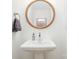 Modern powder room with pedestal sink, wood-framed mirror, and gray towel at 4114 Rutgers Ave, Charlotte, NC 28206