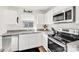 Close-up of the kitchen featuring stainless steel appliances, white cabinets, and granite countertops at 1197 Tangle Ridge Se Dr, Concord, NC 28025