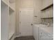 Practical laundry room with washer, dryer, shelving, and white walls at 1957 Tablerock Dr, York, SC 29745