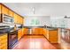 Well-lit kitchen featuring wood cabinets, dark countertops, and stainless steel appliances at 141 Red Brook Ln, Mooresville, NC 28117