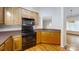 Kitchen with wood cabinets, black appliances, and hardwood floors at 1499 Angela Ct, Lincolnton, NC 28092