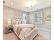 Bright bedroom features a white wood frame bed and a stylish decorative chandelier at 8111 Farm Crossing Ln # 2, Huntersville, NC 28078