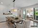 Formal dining room with a modern chandelier, decorative rug, and access to a bright sunroom at 8111 Farm Crossing Ln # 2, Huntersville, NC 28078