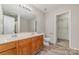 Spacious bathroom with double sinks, wood cabinets, and a walk-in closet at 4803 Roxfield Ln, Charlotte, NC 28215