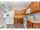 Bright kitchen with wood cabinets, white appliances, and neutral countertops at 4803 Roxfield Ln, Charlotte, NC 28215