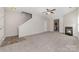 Large carpeted living room with a fireplace and view of stairs and the kitchen at 4803 Roxfield Ln, Charlotte, NC 28215