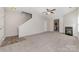 Large carpeted living room with a fireplace and view of stairs and the kitchen at 4803 Roxfield Ln, Charlotte, NC 28215