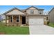 Charming two-story home featuring stone accents, a two-car garage, and a well-manicured lawn at 9916 Manor Vista Trl, Kannapolis, NC 28027