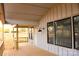 Covered back porch with wooden railing offers outdoor living space and natural light from surrounding windows at 104 Arbor Dr, Waxhaw, NC 28173