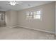 Bright bedroom with carpeted floor, ceiling fan, and large window at 17929 Pages Pond Ct, Davidson, NC 28036