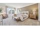 Main bedroom with plush bed, wood accent wall, and large windows at 9912 Manor Vista Trl, Kannapolis, NC 28027