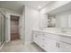 Bathroom with double sink vanity, white cabinets, large mirror, and tiled floor at 9913 Manor Vista Trl, Kannapolis, NC 28027