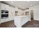 Modern white kitchen with stainless steel appliances, a center island, and hardwood floors at 9913 Manor Vista Trl, Kannapolis, NC 28027