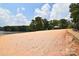 Sandy beach area with lush trees and a covered picnic area along the waterfront at 102 Elm St # 94, New London, NC 28127