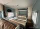 Cozy bedroom with a queen-size bed, mounted TV, and built-in wardrobe at 102 Elm St # 94, New London, NC 28127