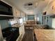 Compact kitchen features a black stove top, microwave, sink, and abundant white cabinetry at 102 Elm St # 94, New London, NC 28127