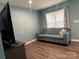 Comfortable living room featuring a plush sofa, laminate floors, and lots of light at 102 Elm St # 94, New London, NC 28127