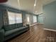 Bright living room featuring a plush sofa, laminate floors, and lots of light at 102 Elm St # 94, New London, NC 28127