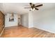 Living room with hardwood floors, exposed brick wall, and ceiling fan at 1201 Green Oaks Ln # G, Charlotte, NC 28205