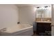 Bathroom with corner tub, dark vanity, and updated lighting at 1520 Yellowstone Ct, Gastonia, NC 28054